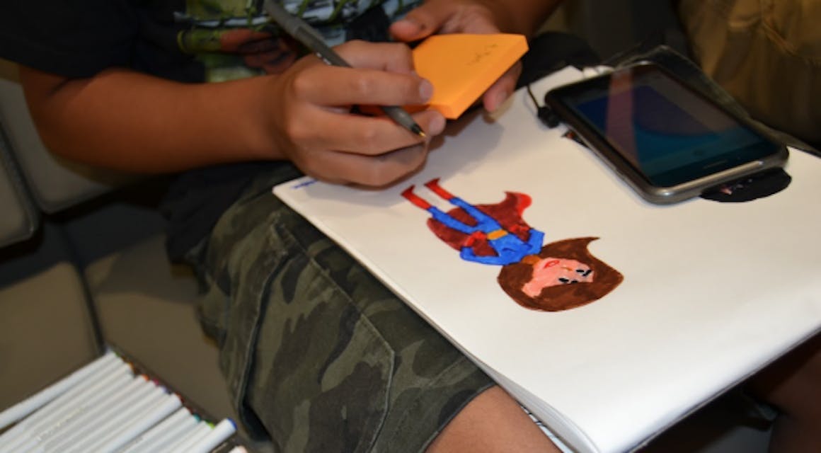 Little boy drawing a super hero