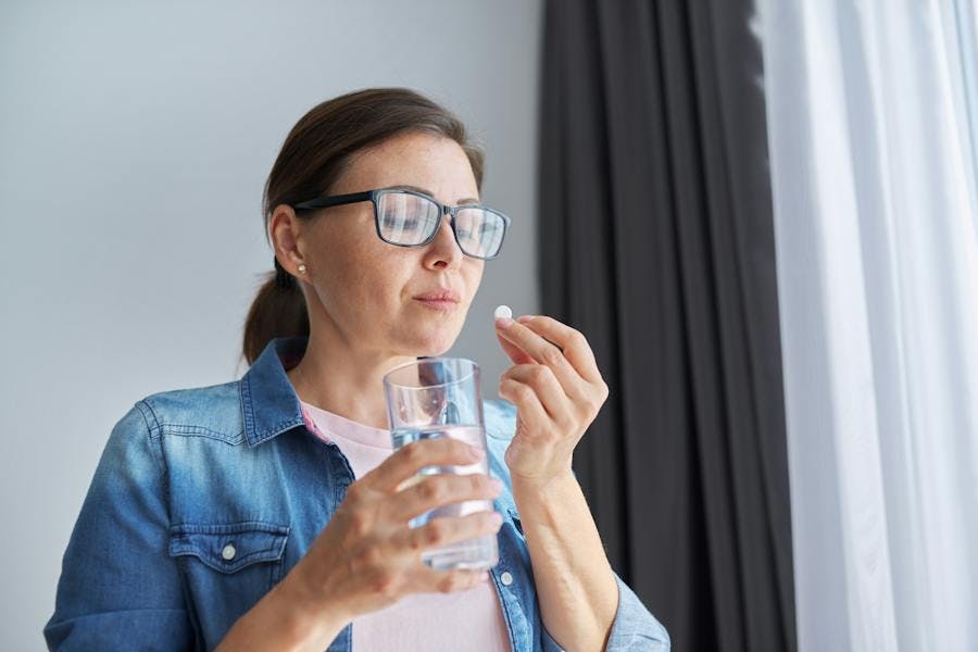 woman taking antibiotics with water