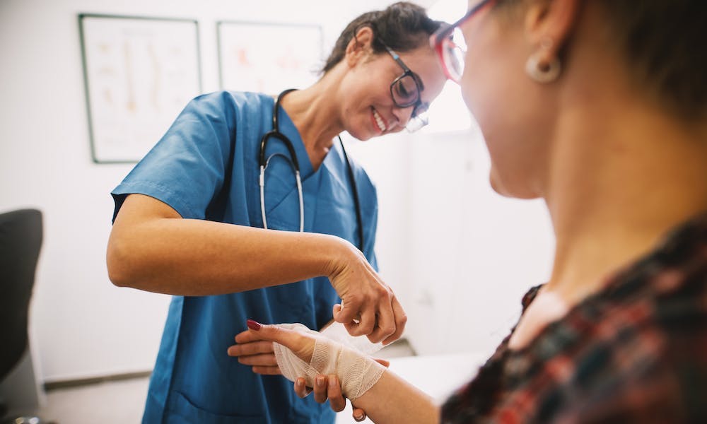 Female nursing bandaging a women's wound