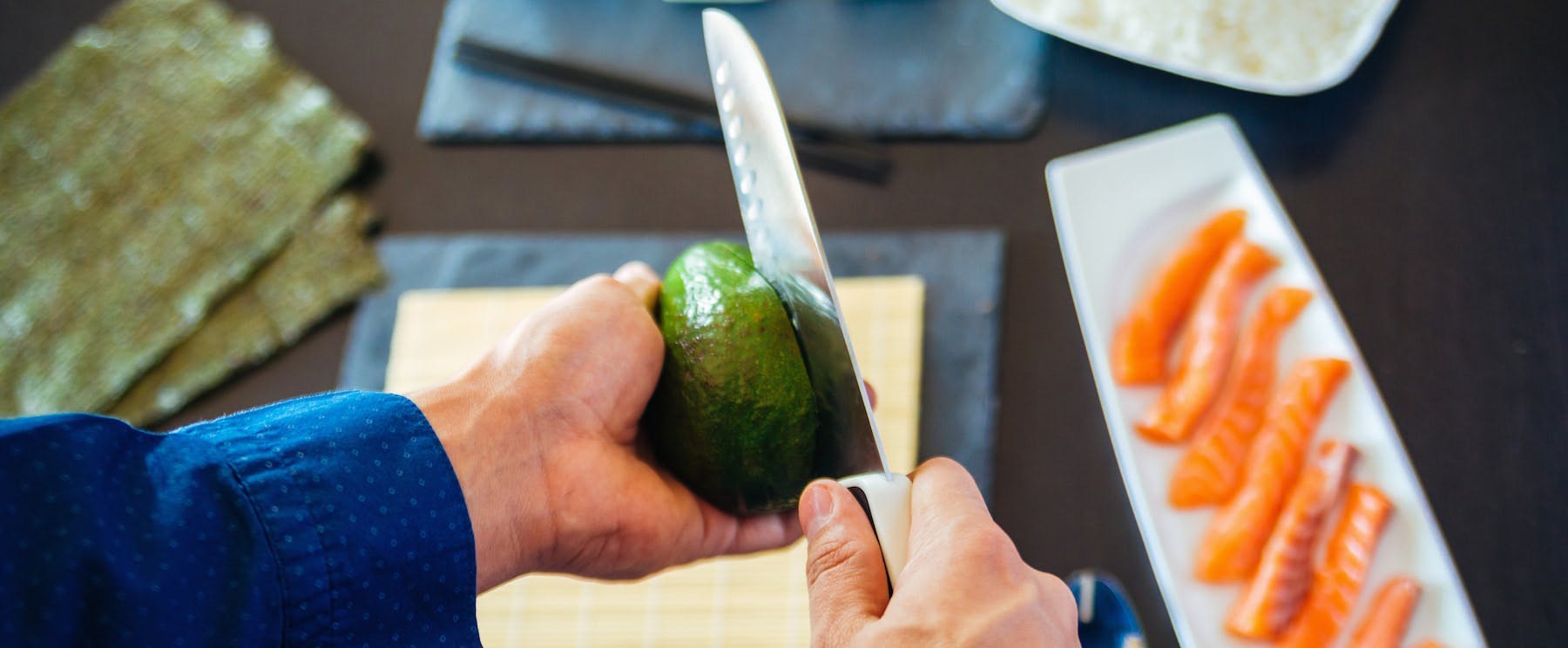 A person cutting an avocado