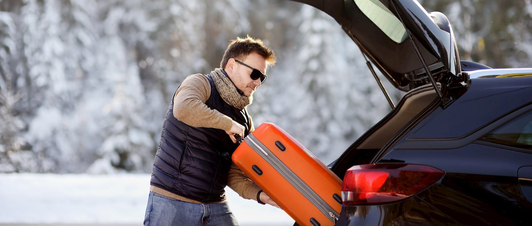 A man loading luggage in a car