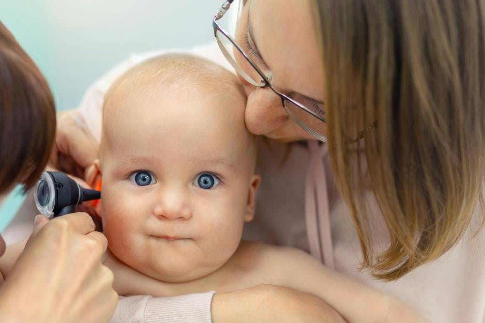 A pediatrician examining a babies ear