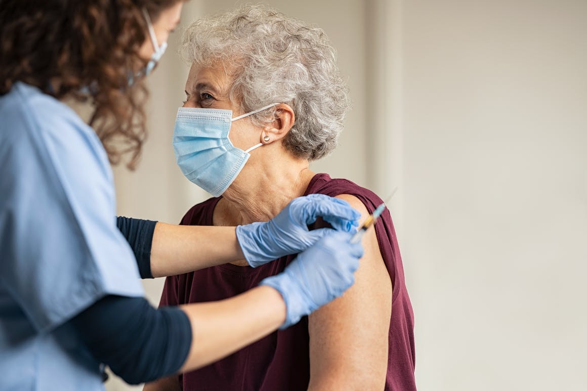 Elderly woman receiving a flu shot