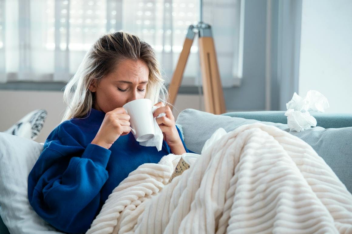 Sick woman drinking tea from a mug