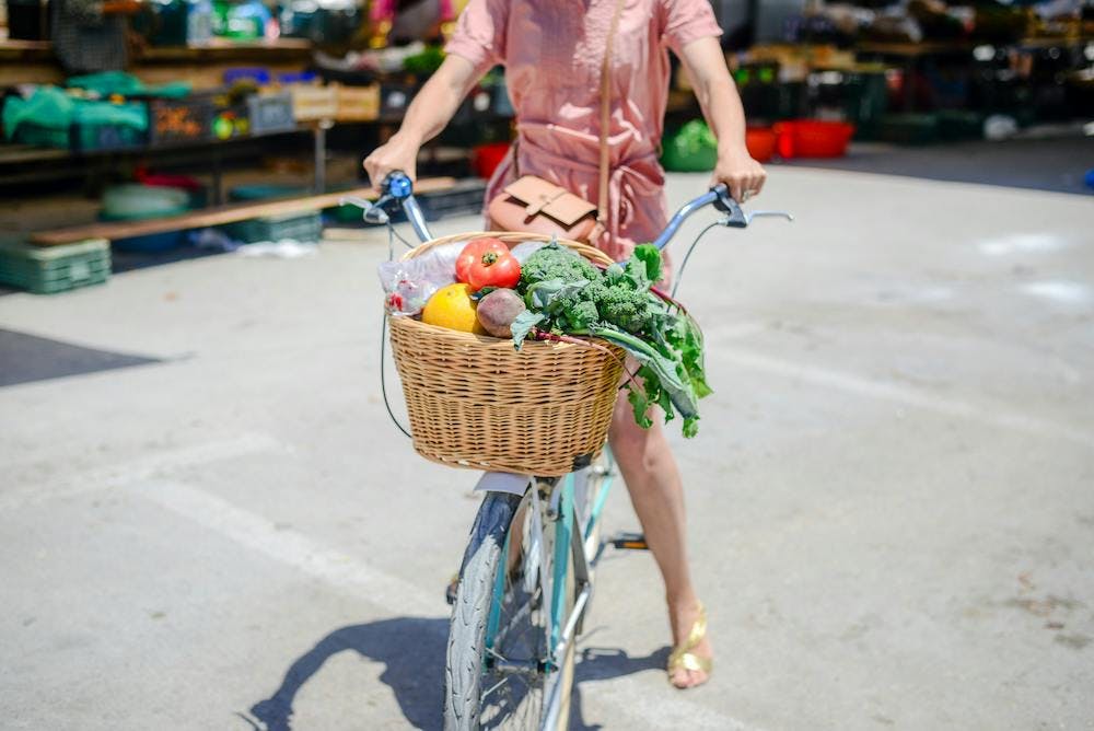 A girl on a bicycle with vegetables