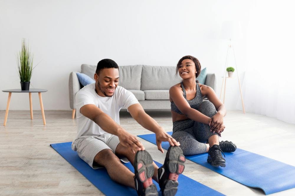 A fit young couple exercising on a yoga mat 