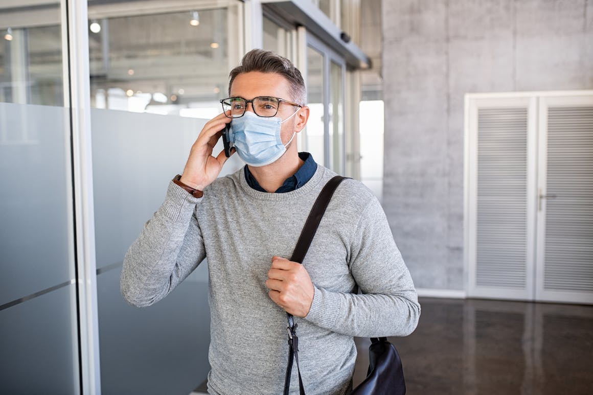 Man on the phone wearing a mask to protect against COVID-19